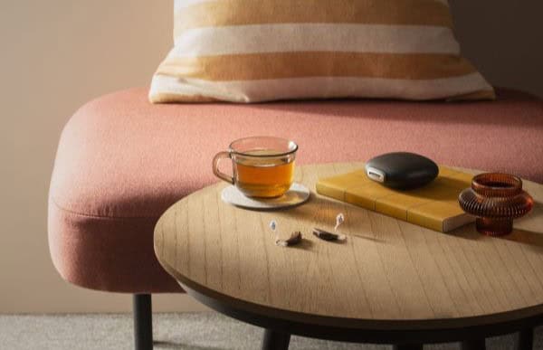 digital hearing aids on a table with their charging case